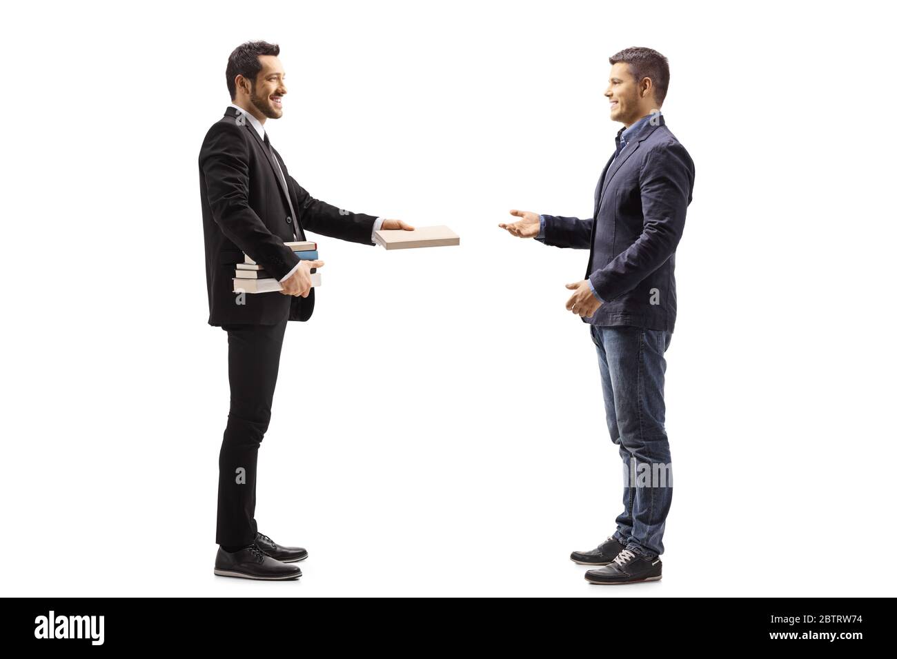 Profilo a lunghezza intera di un uomo in un vestito nero dando un libro ad un altro uomo isolato su sfondo bianco Foto Stock