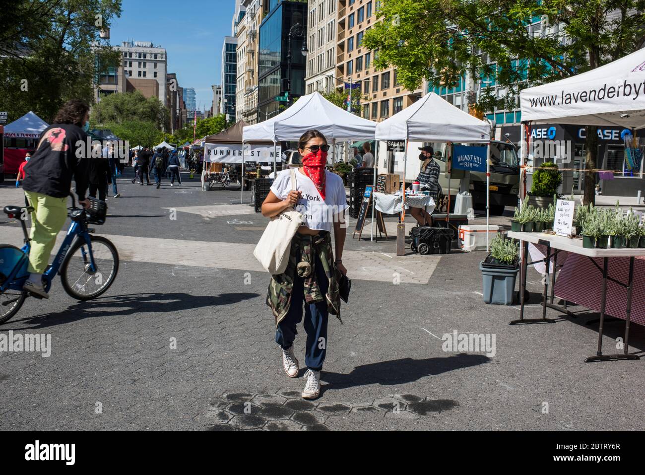 New York City, New York, USA - 21 maggio 2020: Mercato-goer indossare bandana come copertura facciale mentre si fa shopping al mercato agricolo di Union Square, New Y Foto Stock