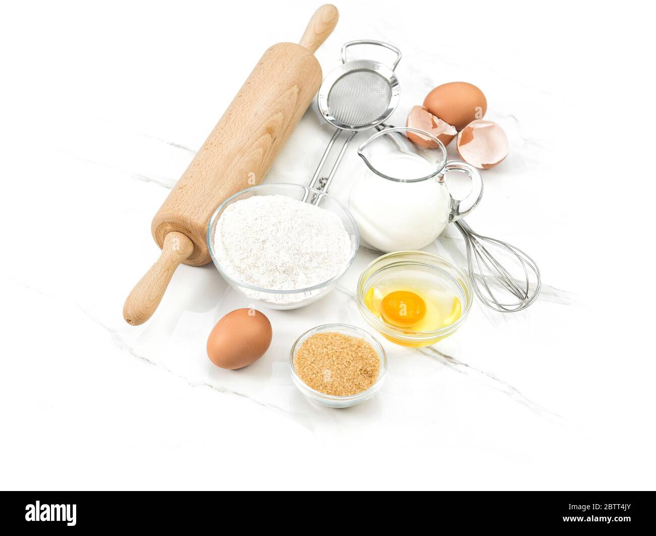 Ingredienti alimentari uova, farina, zucchero, latte. Utensili da cucina. Preparazione dell'impasto Foto Stock
