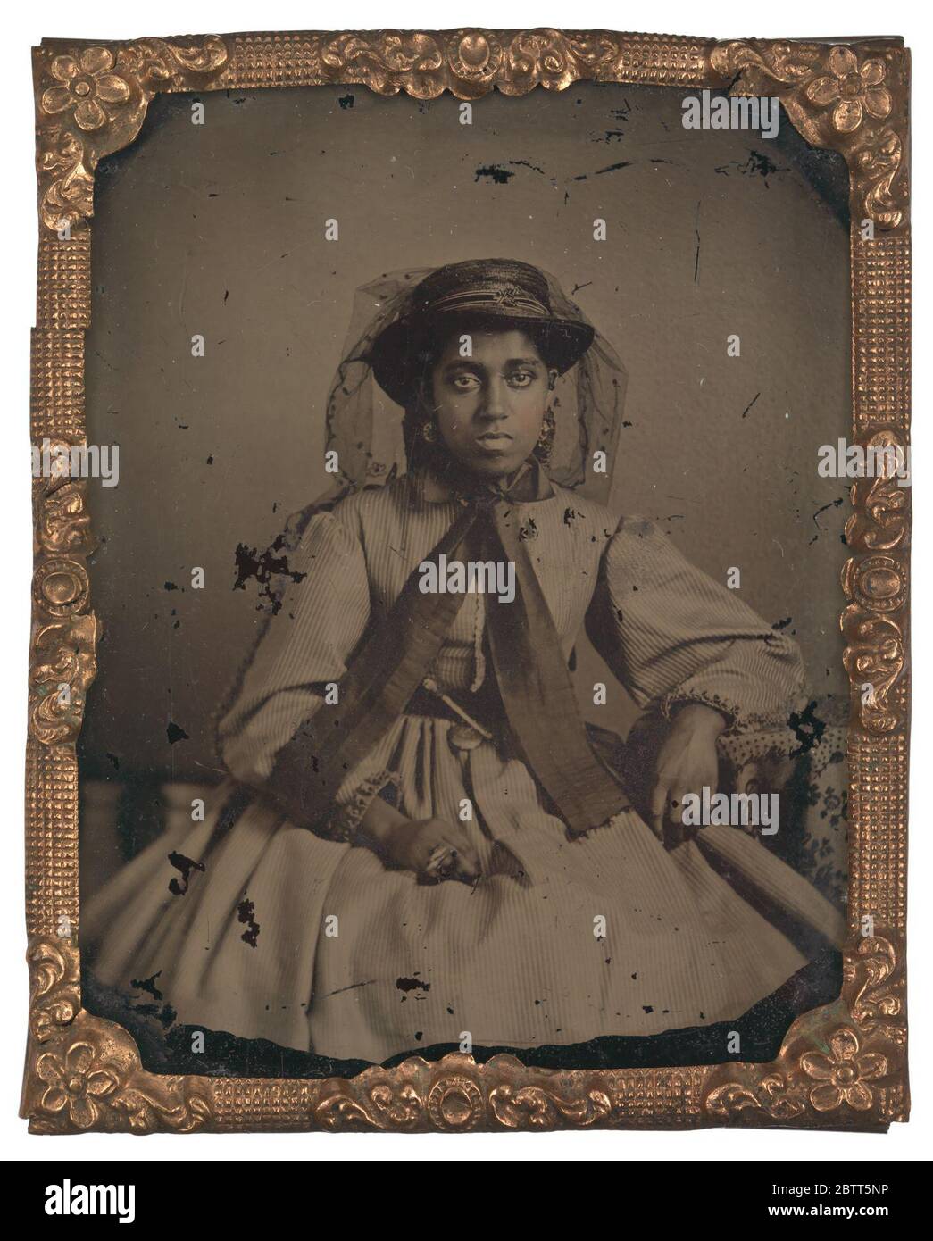 Ambrotipo di una giovane donna non identificata. Questa fotografia in bianco e nero è un ritratto di tre quarti di lunghezza di una giovane donna non identificata seduta con il gomito sinistro appoggiato su un tavolo. Foto Stock Ambrotipo di una giovane donna non identificata. Questa fotografia in bianco e nero è un ritratto di tre quarti di lunghezza di una giovane donna non identificata seduta con il gomito sinistro appoggiato su un tavolo. Foto Stock