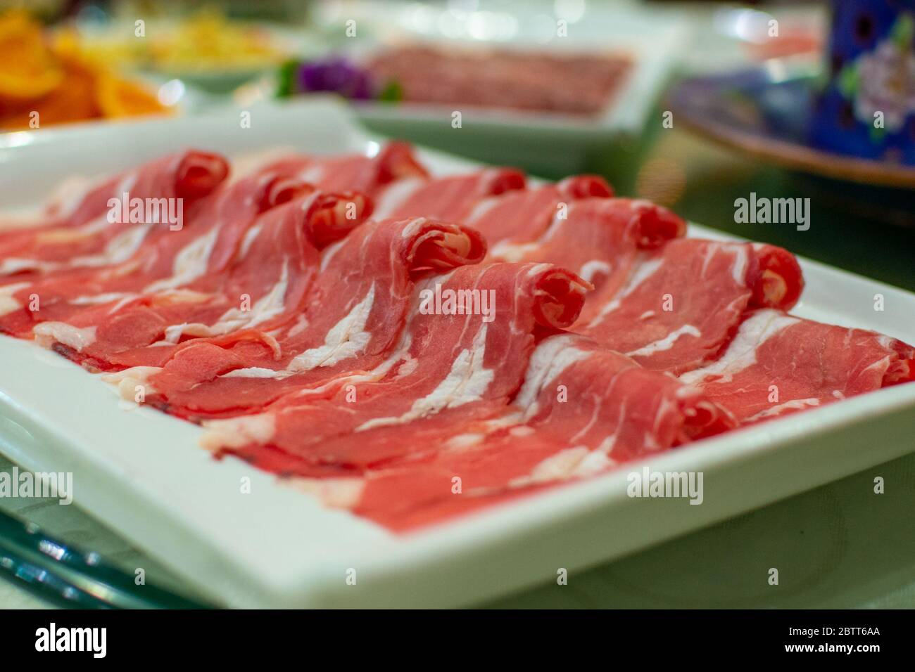 Sottili fette di carne di manzo, pronte per essere cotte in pentola calda, piatto popolare cinese Foto Stock