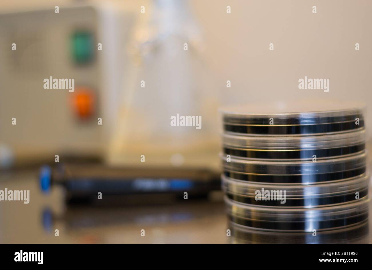 Materiale per un esperimento di ricerca in vitro: Capsule di petri contenenti terreno di coltura, pinzette, micropipette e sterilizzatore automatico Foto Stock