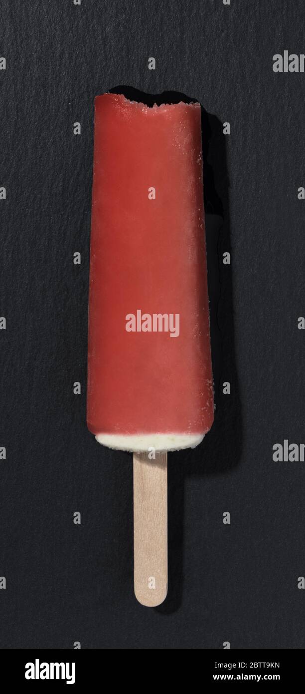 Vista dall'alto del gelato al gusto di melone d'acqua rosso su sfondo di pietra nera Foto Stock