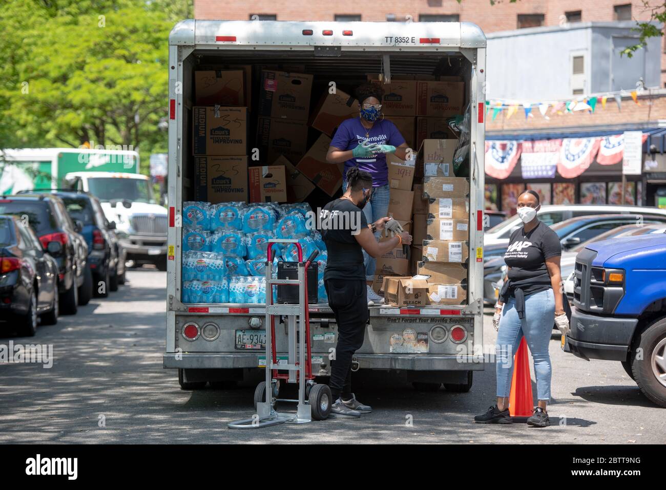 Lavoratori e volontari scaricano il cibo donato presso il Queensbridge Houses, un complesso di alloggi pubblici della New York City Housing Authority (NYCHA), il 27 maggio 20 Foto Stock