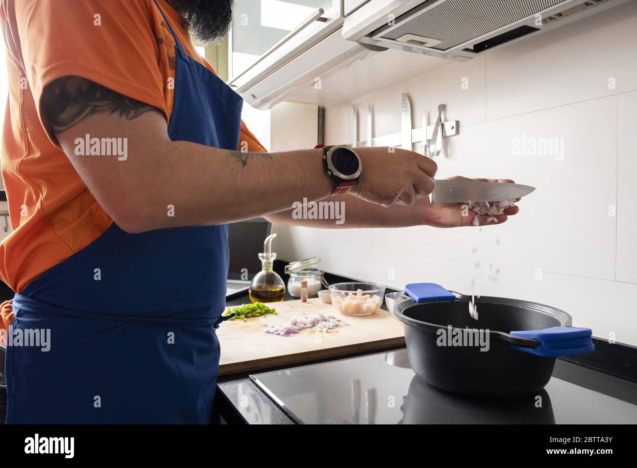 uomo irriconoscibile mettendo cipolle tritate in una pentola per preparare un pasto sano, concetto di cucina casalinga Foto Stock