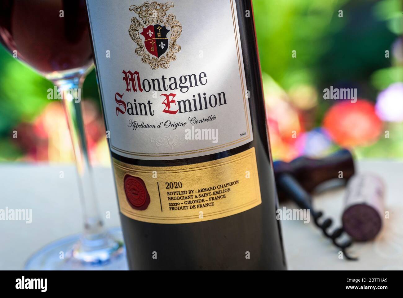 BOTTIGLIA DI SAINT EMILION e bicchiere di vino post '2020' Montagne Saint-Emilion in una degustazione di vini all'aperto situazione sul tavolo giardino francese terrazza Foto Stock