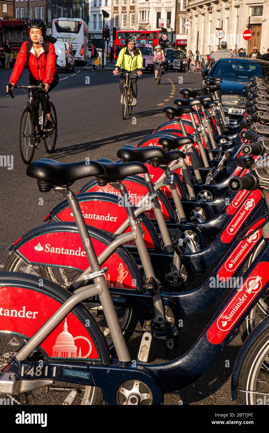 Biciclette che passano da Londra TFL a Santander sponsorizzato linea di noleggio biciclette rosse a Southwark Street con pendolari londinesi in bicicletta biciclette biciclette che indossano caschi di sicurezza in bicicletta passato, trasporto per Londra Southwark Londra UK Foto Stock