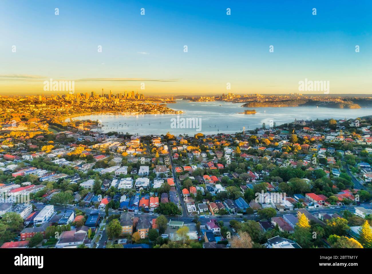 Ricchi sobborghi orientali della città di Sydney intorno al porto con vista aerea, con luce soffusa e cielo blu. Foto Stock