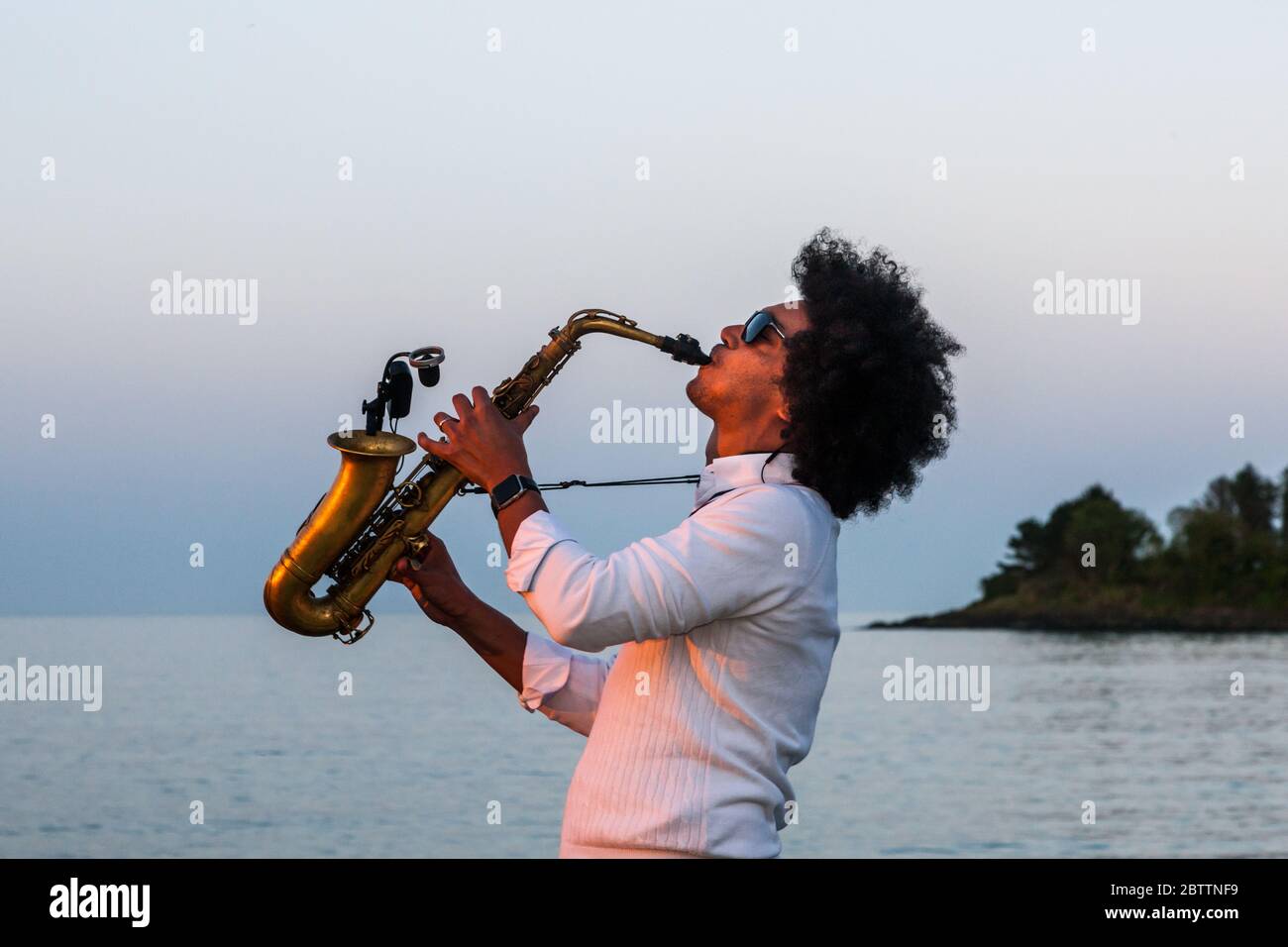 Fountaintown, Cork, Irlanda. 27 maggio 2020.Chris Jordan-Engel gioca il suo sax alto sulla riva per i kayak che hanno partecipato al ‘mremorial paddle out’ che ha avuto luogo a Funkytown a Fountastown, Co. Cork, Irlanda - Credit; David Creedon / Alamy Live News Foto Stock