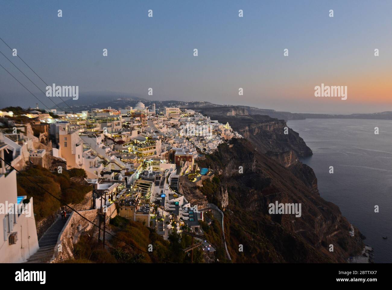 Tramonto sul mare e crepuscolo presso le case bianche di Fira, Stantorini. Grecia Foto Stock