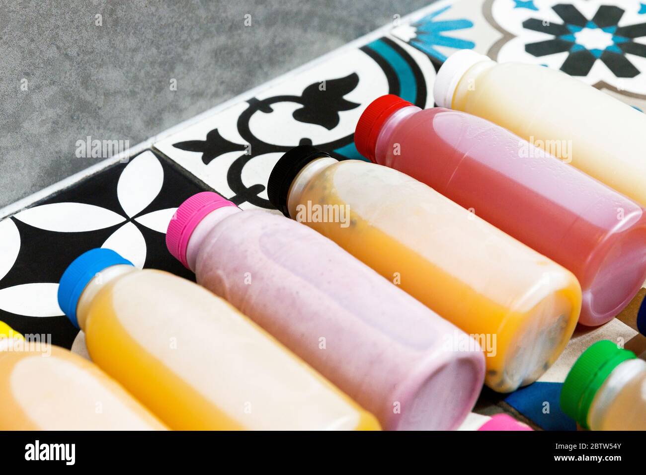 Spremute fresche e bottiglie di frullato in una linea. Foto Stock