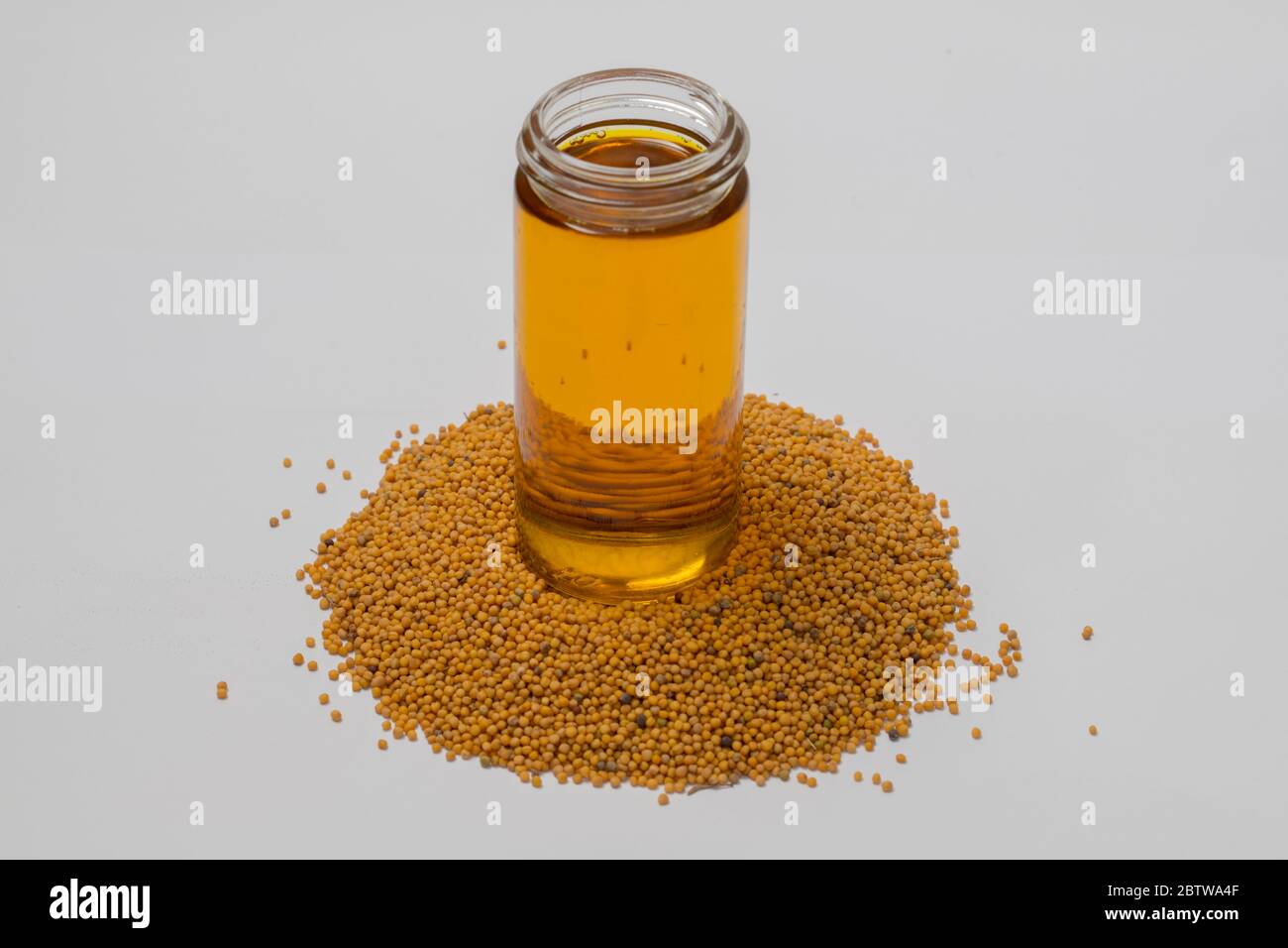 Vista ravvicinata della senape cruda e dell'olio di senape su sfondo bianco. Foto Stock