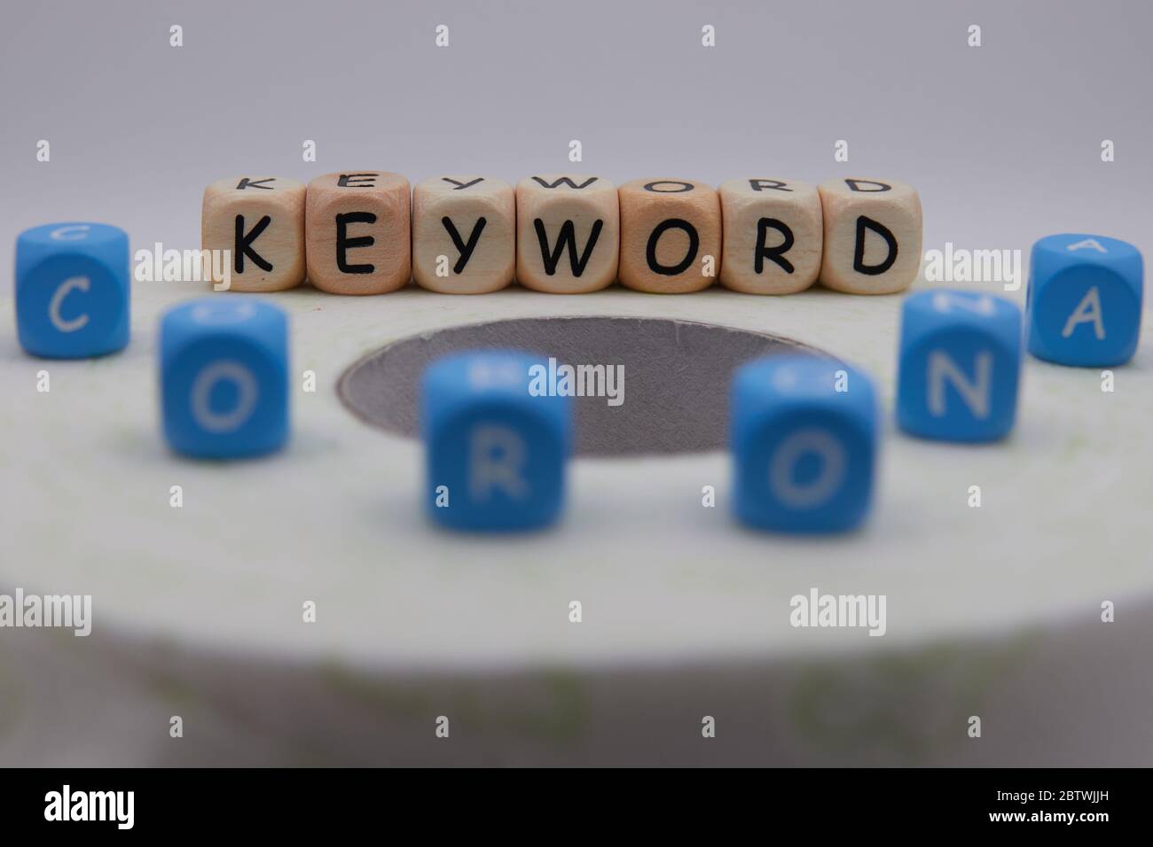 Parola chiave corona su carta igienica verdastra fuori fuoco Foto Stock