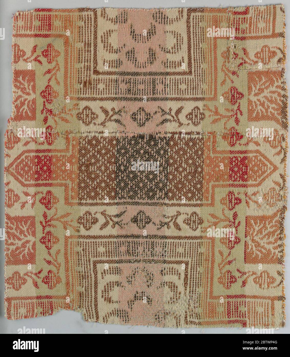 Frammento di coverlet. Ricerca in ProgressGeometriche cornice con ornamenti floreali in spazi che separano questi elementi. Terreno marrone chiaro con bande verticali rosa chiaro e giallo chiaro; modello nei colori più profondi di rosso, arancione, marrone e marrone scuro. Foto Stock