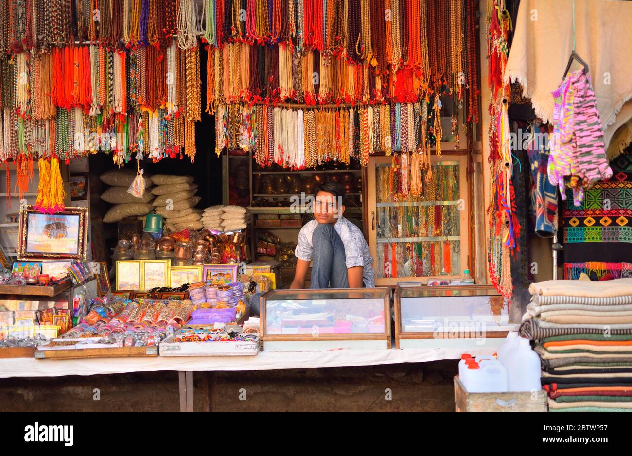 Un uomo che vende gioielli artificiali nel suo negozio. Foto Stock