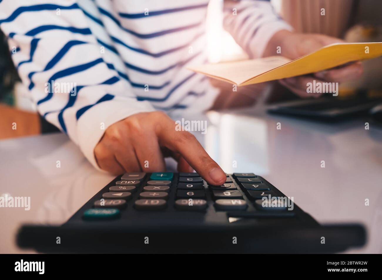 Mani di affari che tengono il libretto di salvataggio del cliente con calcolatore, Foto Stock