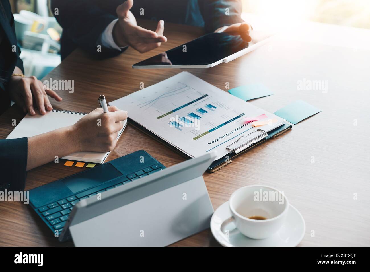 Il team aziendale si occupa di lavorare con il piano finanziario, riunioni, discussioni, brainstorming con il tablet sulla scrivania dell'ufficio, Foto Stock