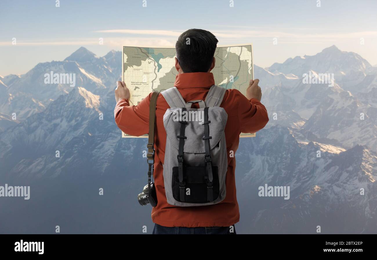 Un giovane viaggiatore uomo sulla cima della montagna iceberg con zaino nella natura e guardare la direzione di ricerca sulla mappa posizione, Avventura e viaggio in Foto Stock