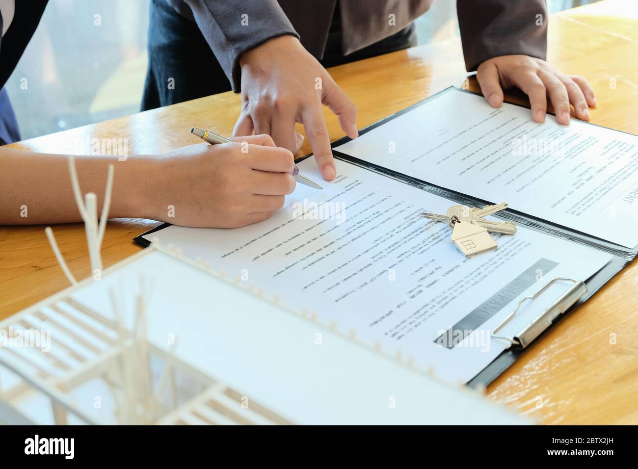 Agente immobiliare offrire mano per cliente firma contratto contratto per acquistare o vendere casa. Foto Stock