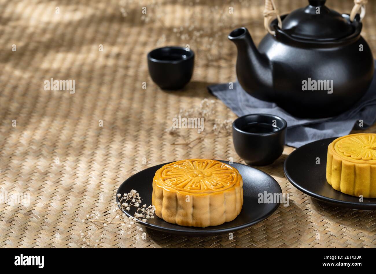 Torta di Luna con tazza di tè caldo sullo sfondo della tavola di legno con copyspace per il vostro testo, concetto di festival asiatico tradizionale Foto Stock