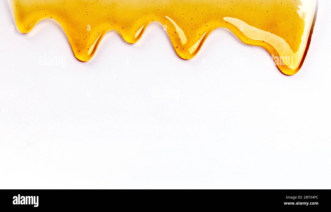 Il miele che gocciola è ripetibile dall'alto in bianco con copyspace e testo Foto Stock