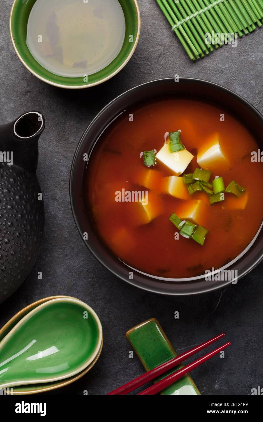 Zuppa tradizionale giapponese miso con tofu e cipolla primaverile. Con tè verde in vaso e ciotole. Vista dall'alto Foto Stock