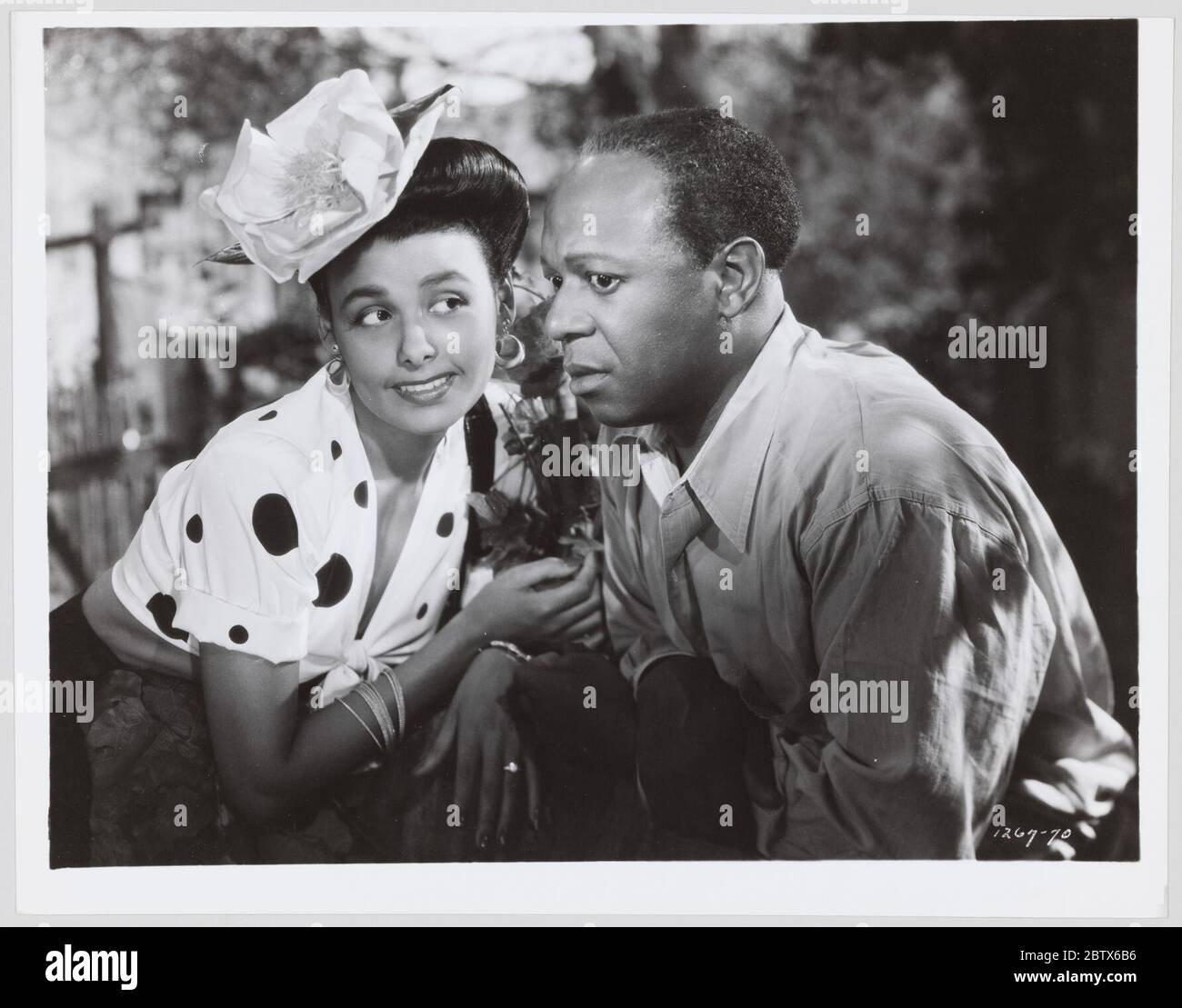 Film fermo per Cabin in the Sky. Un film ancora per il film musicale del 1943 Cabin in the Sky. La foto è in bianco e nero. A sinistra della foto inizia una donna con un grande fiore di colore chiaro, puntellato sul lato anteriore destro dei capelli. Foto Stock