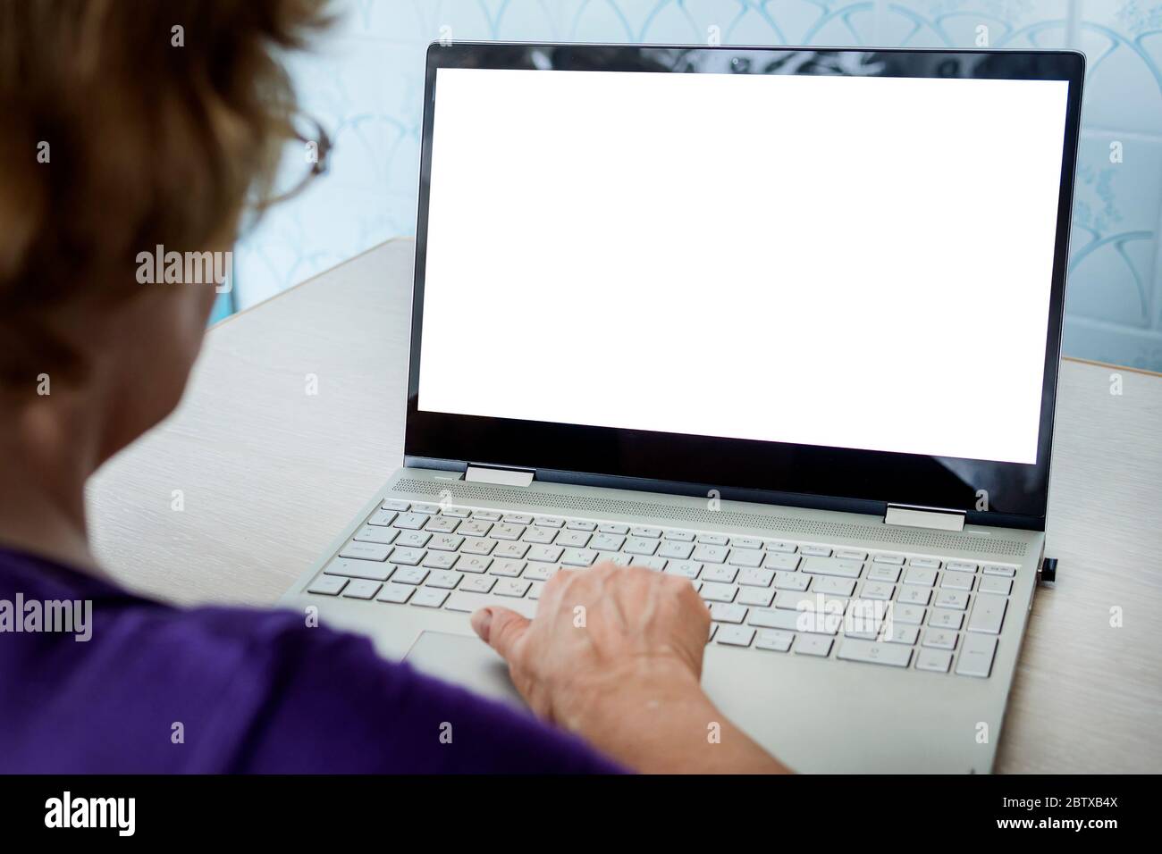 Tecnologia moderna e età avanzata. nonna in contatto online. Donna giovane allegra che mostra schermo vuoto sul computer portatile, spazio vuoto per test e. Foto Stock
