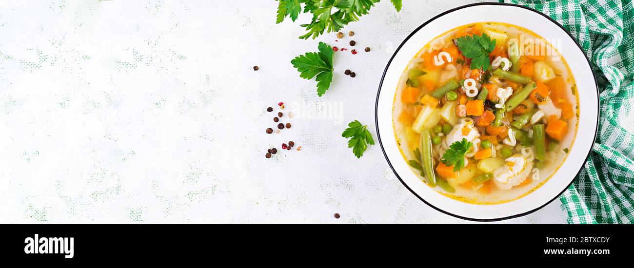 Minestrone, zuppa italiana di verdure con pasta su tavola leggera. Vista dall'alto, banner, spazio per la copia Foto Stock