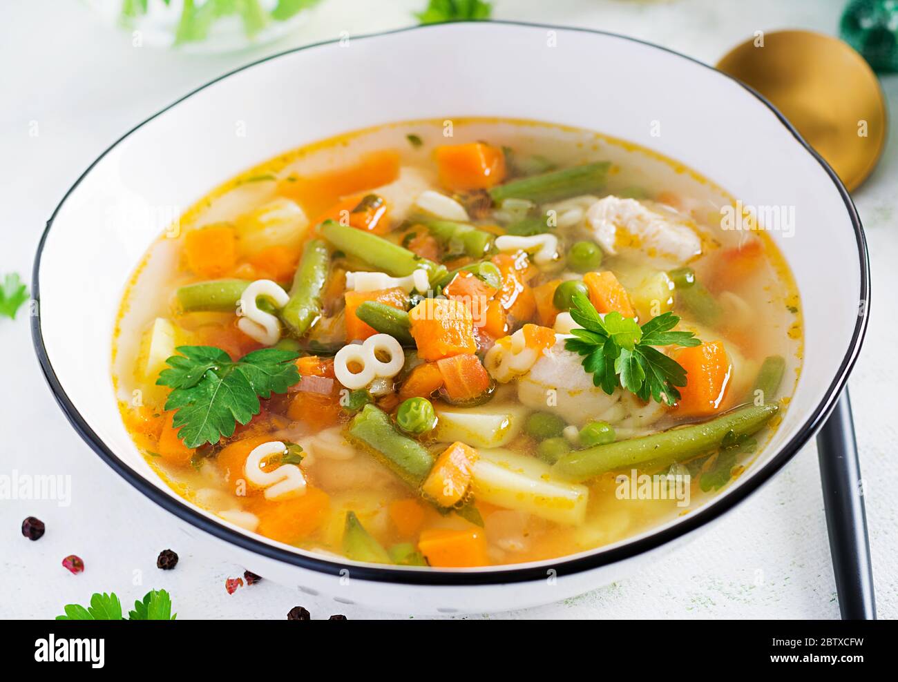 Minestrone, zuppa italiana di verdure con pasta su tavola leggera. Foto Stock