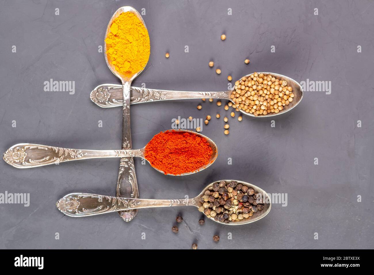 Spezie secche di colori diversi nei cucchiaini. Vista dall'alto Foto Stock