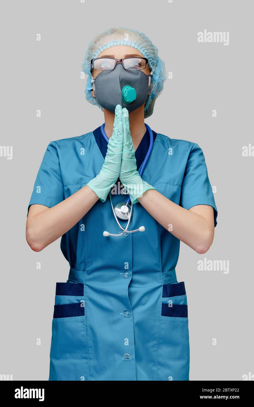 medico infermiere donna che indossa maschera protettiva e guanti in lattice - pregando nad sperando gesto Foto Stock