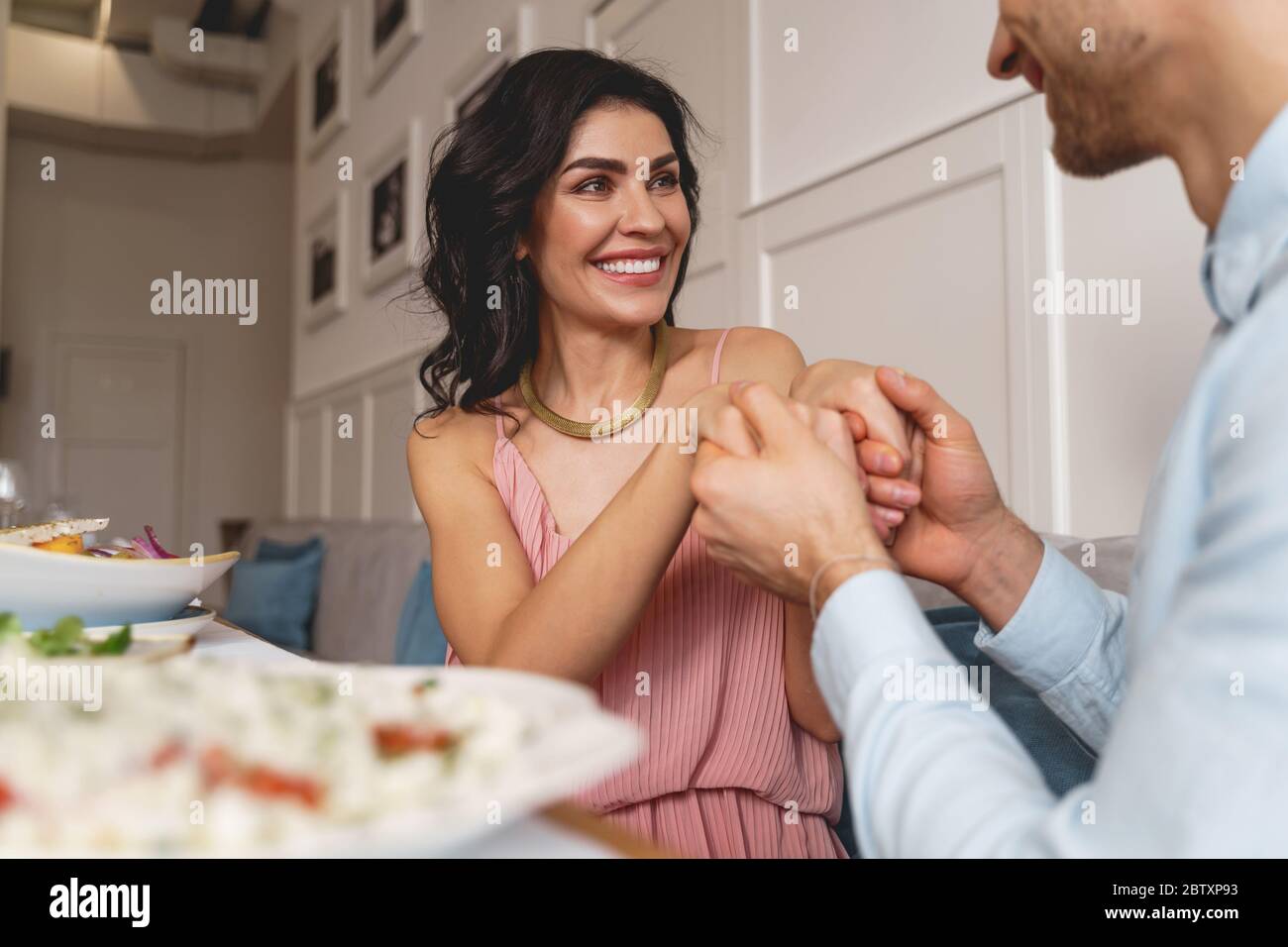 Felice giovane donna che passa il tempo con gentiluomo in caffetteria Foto Stock