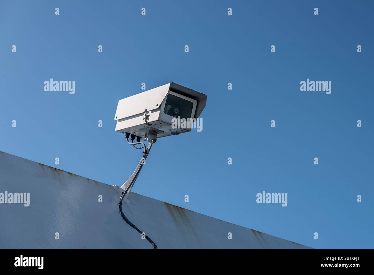 Telecamera di sicurezza singola, contro un cielo blu profondo. Foto Stock