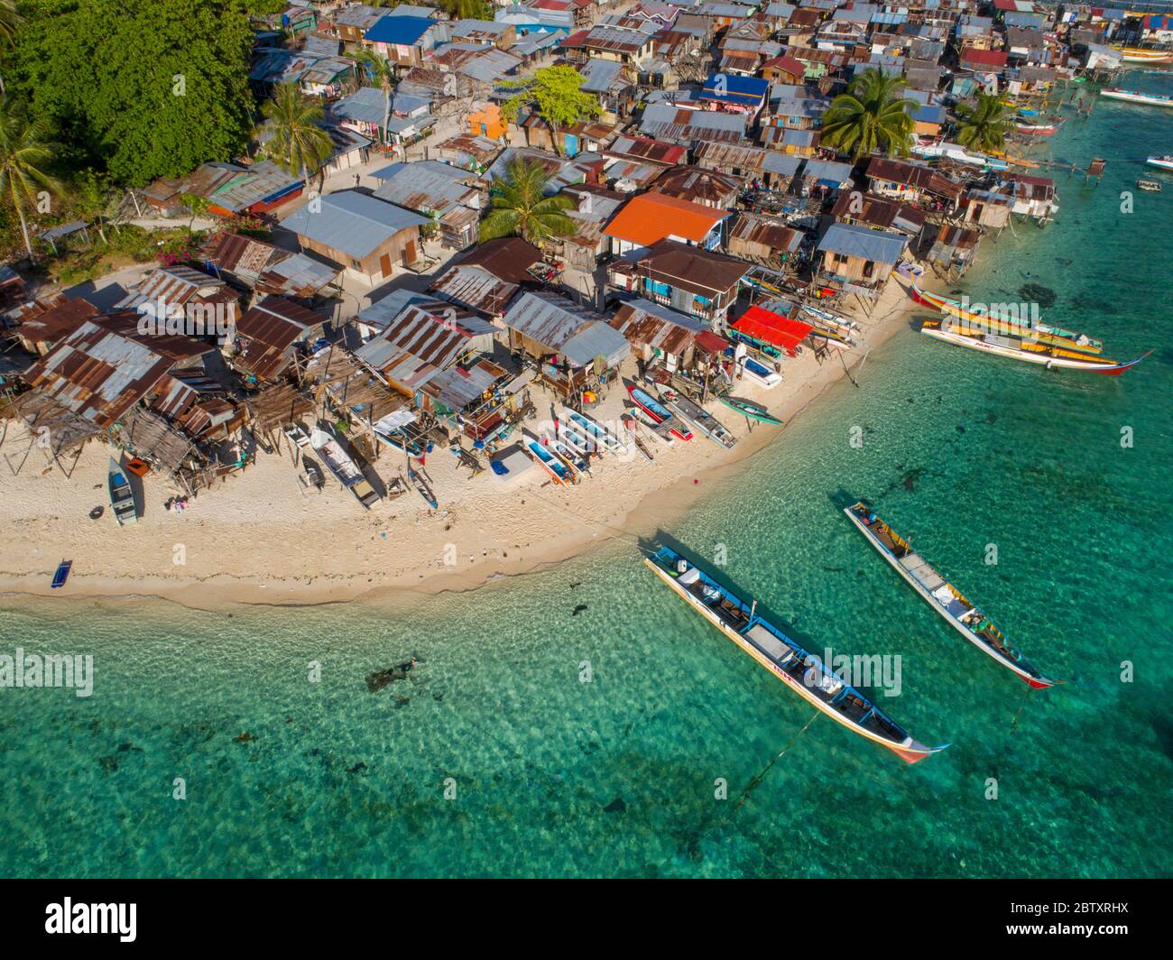 Una foto drone di bajau mare gitsy capanne e barche su una spiaggia a Mabul Island, Sabah, Borneo, Malesia. Foto Stock