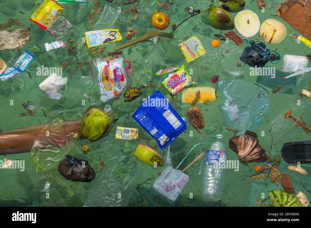 Rifiuti di plastica e inquinamento galleggianti in mare al largo della spiaggia a Mabul Island, Sabah, Borneo, Malesia. Foto Stock