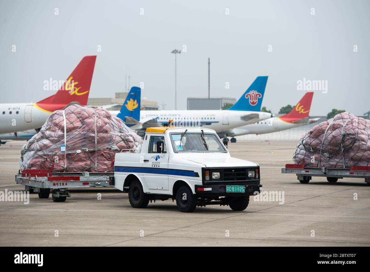 (200528) -- CHANGSHA, 28 maggio 2020 (Xinhua) -- UN trattore trasporta i pacchi dalle imprese transfrontaliere di commercio elettronico al piazzale di parcheggio presso l'aeroporto internazionale Changsha Huanghua di Changsha, provincia di Hunan, 28 maggio 2020. Un aereo che trasportava quasi 40,000 pacchi dalle imprese transfrontaliere di e-commerce partì da Changsha a Mosca, Russia, giovedì. Questo è stato il primo volo della normale rotta aerea per il trasporto merci sul commercio elettronico transfrontaliero verso la Russia, il che significa il funzionamento di tale rotta in Hunan. Operato tre volte alla settimana, il percorso servirà da d Foto Stock