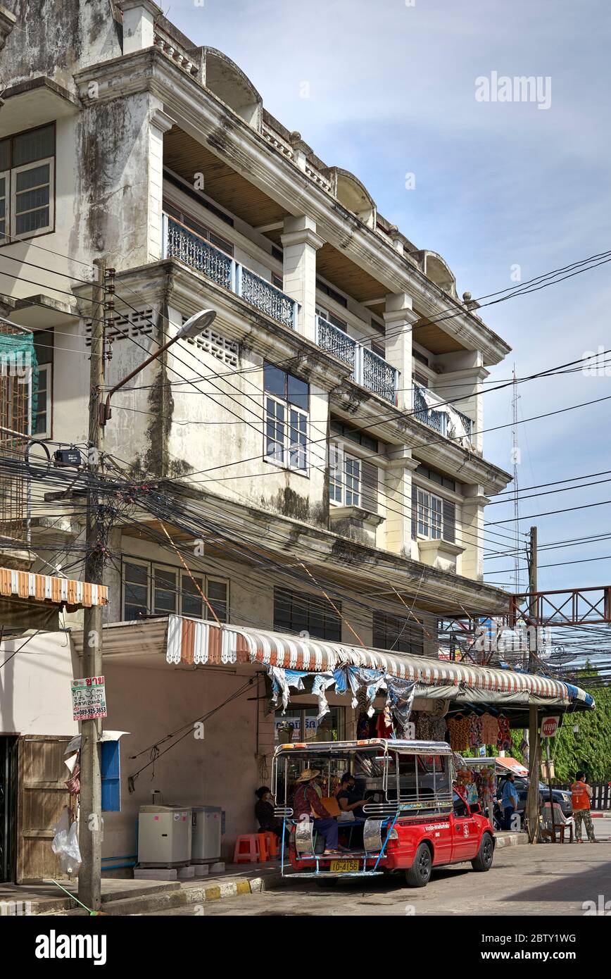 Thailandia scena di strada con la gente seduta in un autobus Songthaew baht contro un edificio di abitazione. Sud-est asiatico Foto Stock