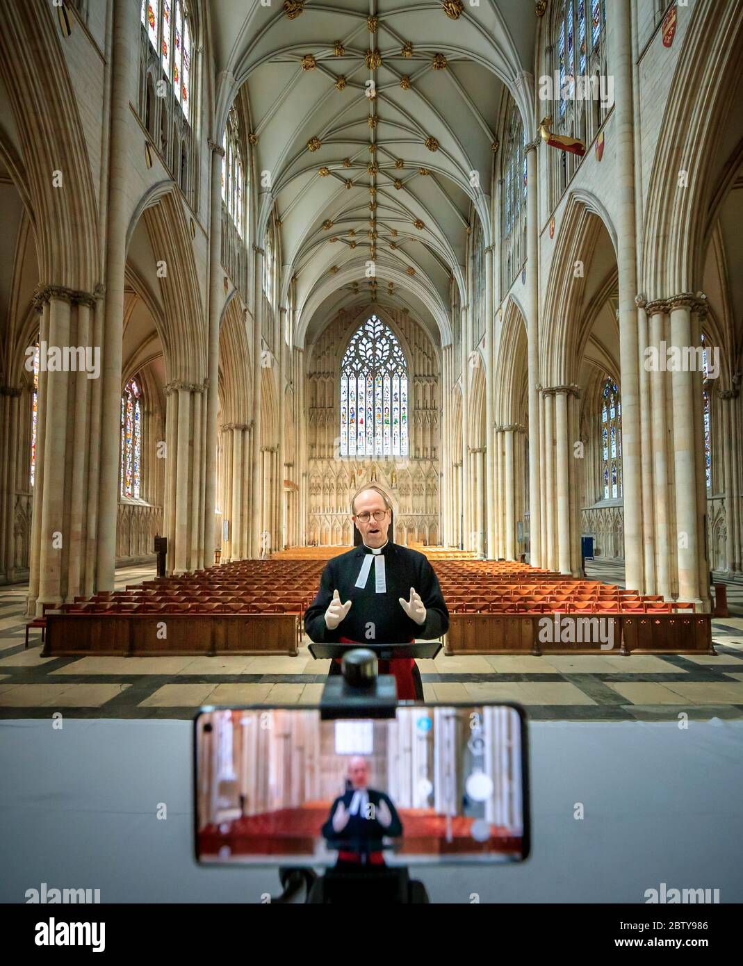 Il Revd Michael Smith, il canonico Pastore della cattedrale di York Minster, prova un servizio digitale di Evensong all'interno della cattedrale, mentre il governo si muove verso l'introduzione di misure per portare il paese fuori dalla chiusura. Foto Stock