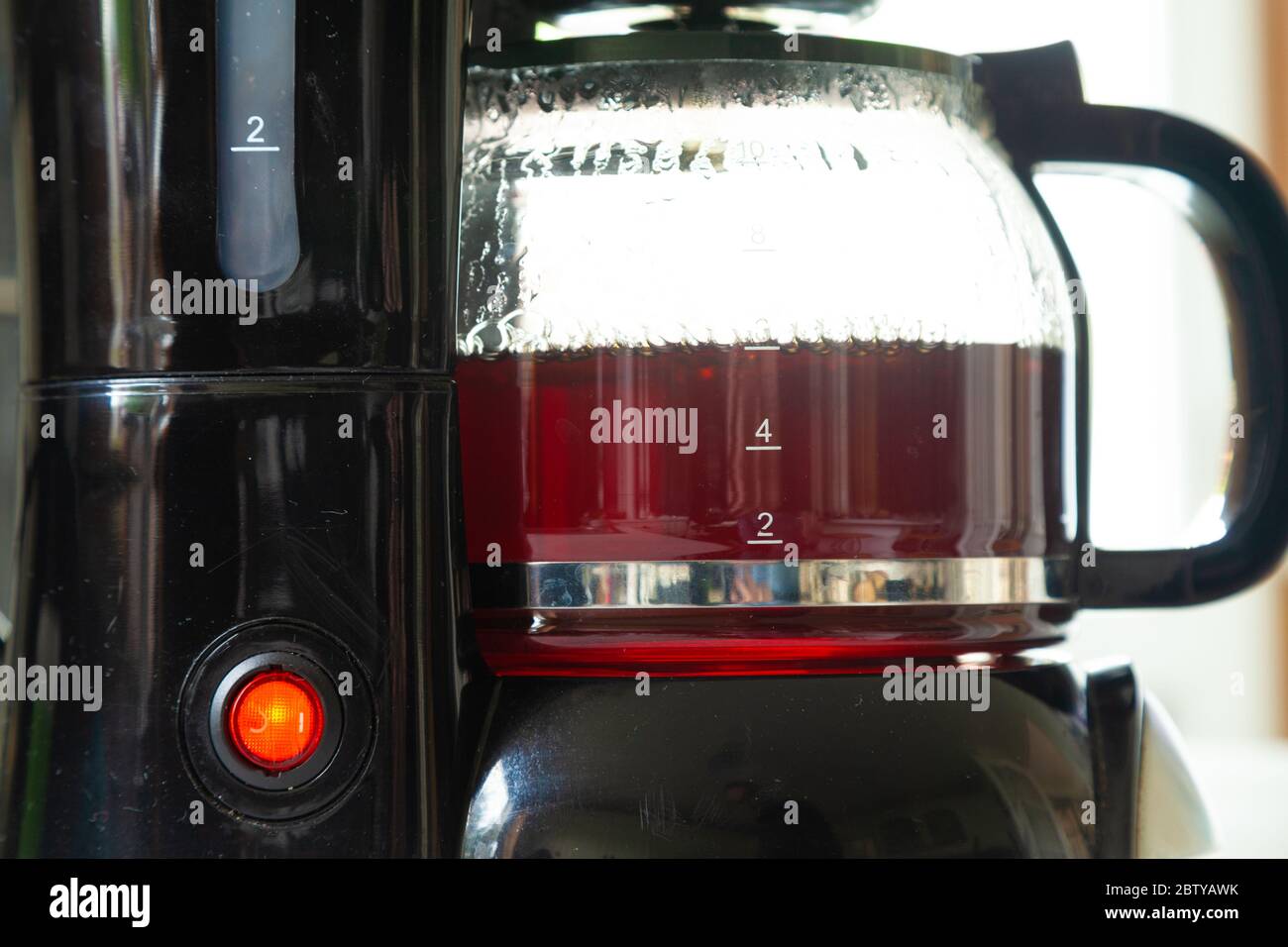 Primo piano di una macchina per il caffè in plastica per preparare una tazza di caffè fresca. Foto Stock