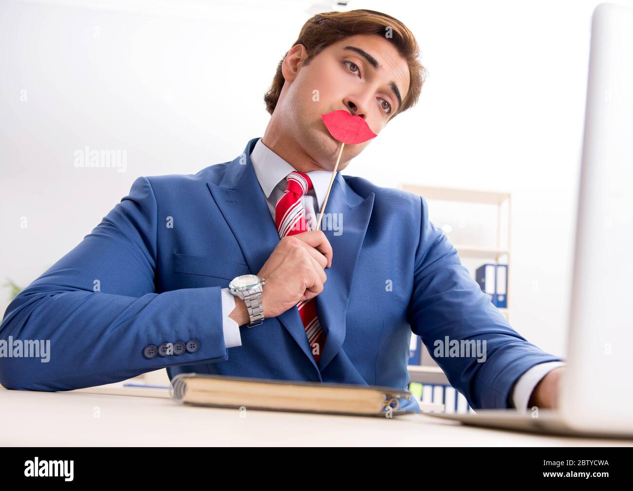 Il bisinessman divertente con le labbra false in ufficio Foto Stock
