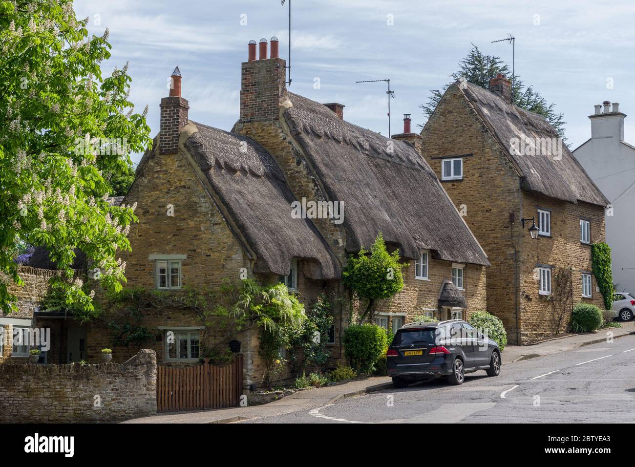 Graziose case di paglia in Spring nel villaggio di Boughton, Northamptonshire, Regno Unito Foto Stock
