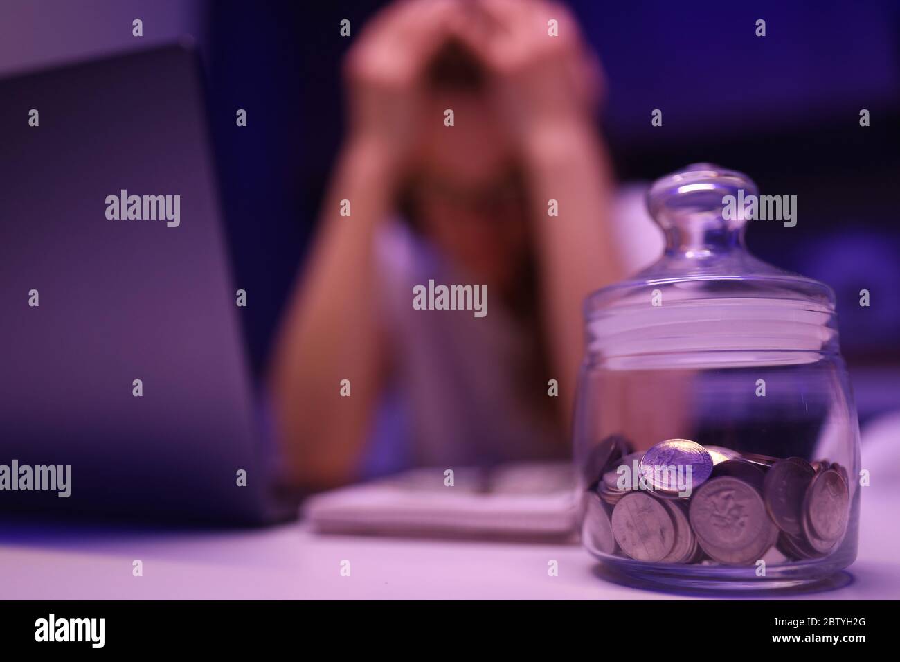 Un adulto e un computer portatile sono sconvolati sulla scrivania Foto Stock