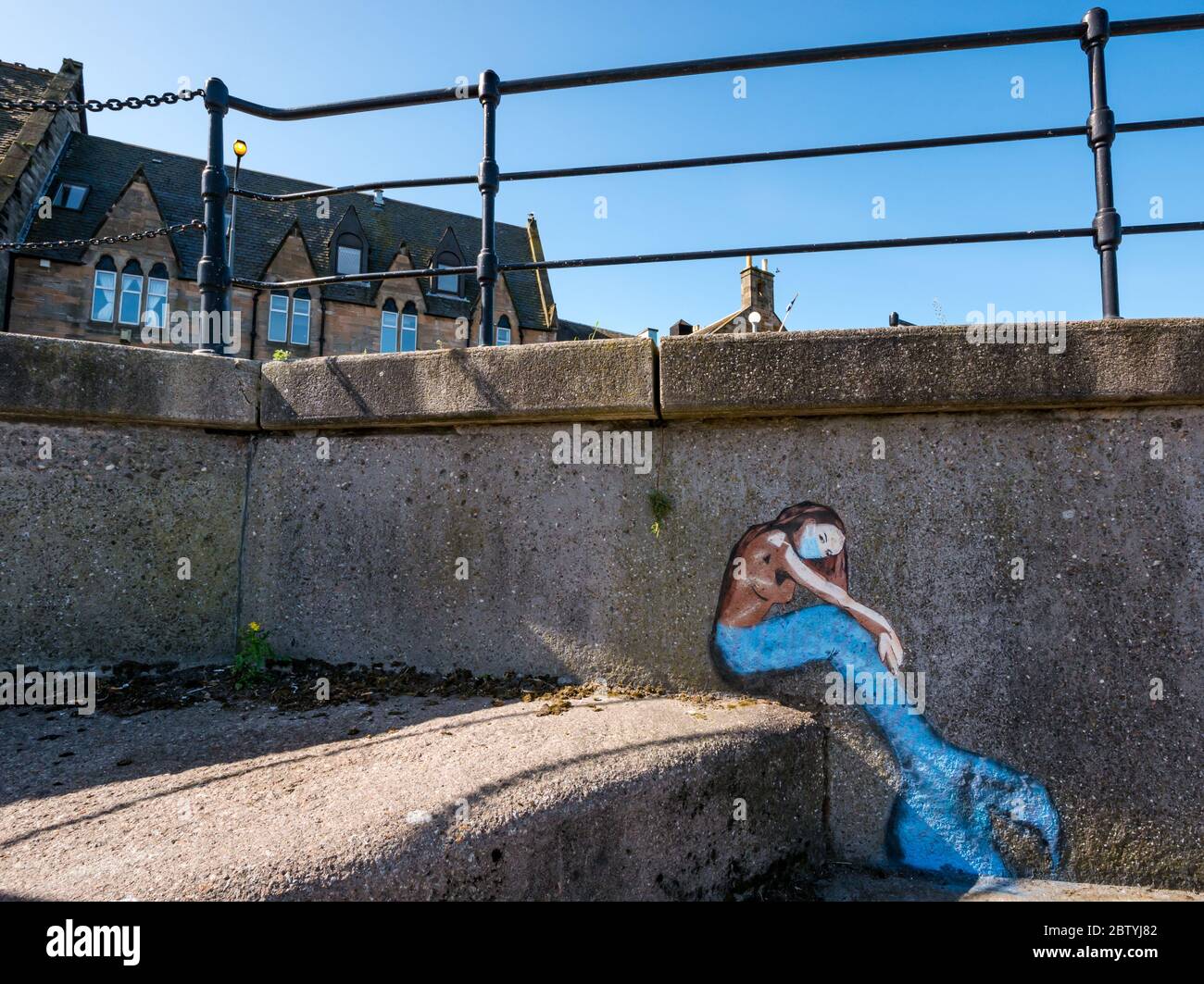 Disegno di graffiti della sirena con maschera chirurgica pandemica Covid-19, porto di Newhaven, Edimburgo, Scozia, Regno Unito Foto Stock