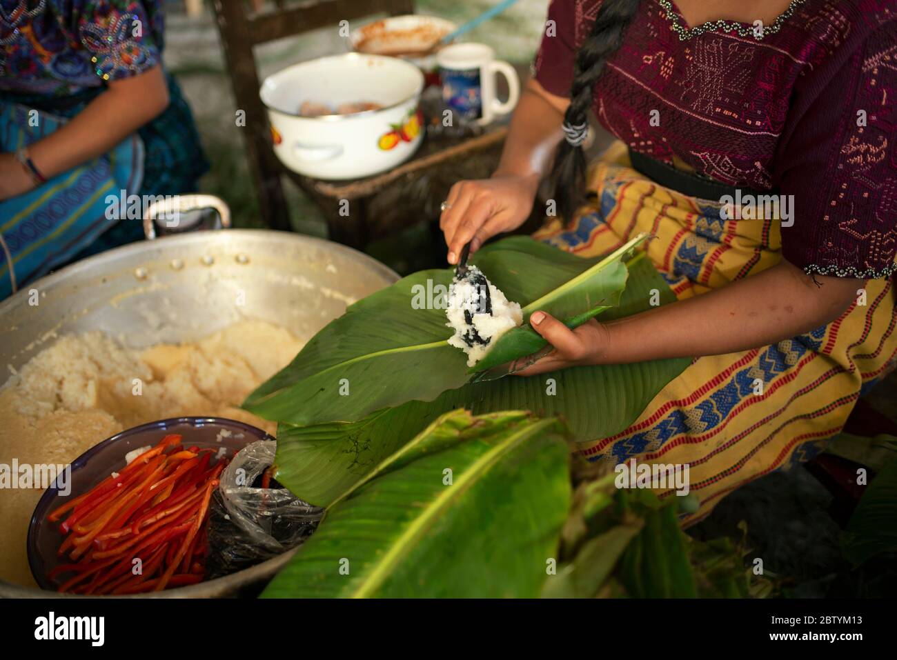 Tamales nella preparazione con buccia di mais e peperoncino, carne avvolta in foglie di banana poi cucinato in un grande pentola. Natale giorno di tradizione Maya in Guatemala Foto Stock