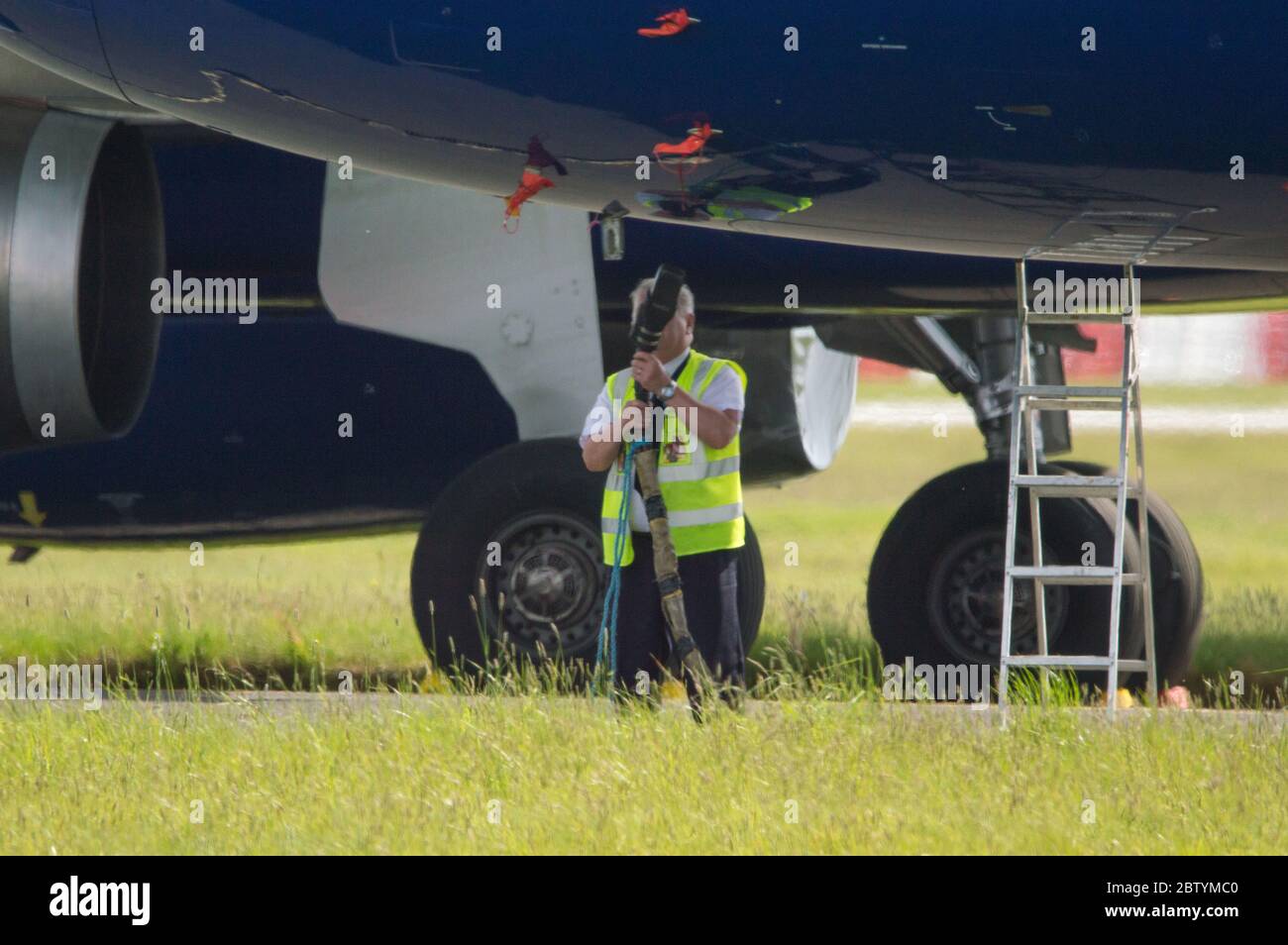 Glasgow, Scozia, Regno Unito. 28 Maggio 2020. Nella foto: Gli equipaggi di terra della British Airways all'aeroporto internazionale di Glasgow servono la collezione di aerei Airbus A319/A320/A321 con base a terra che giacciono dormienti e senza luce mentre le compagnie aeree lavorano a che fare con la sua massa di aerei a terra nella loro flotta. Ci sono costi fissi che BA deve soddisfare per assicurarsi che i loro aerei siano aerei. Per sopravvivere BA ha già assacionato un quarto del loro personale. Credit: Colin Fisher/Alamy Live News Foto Stock