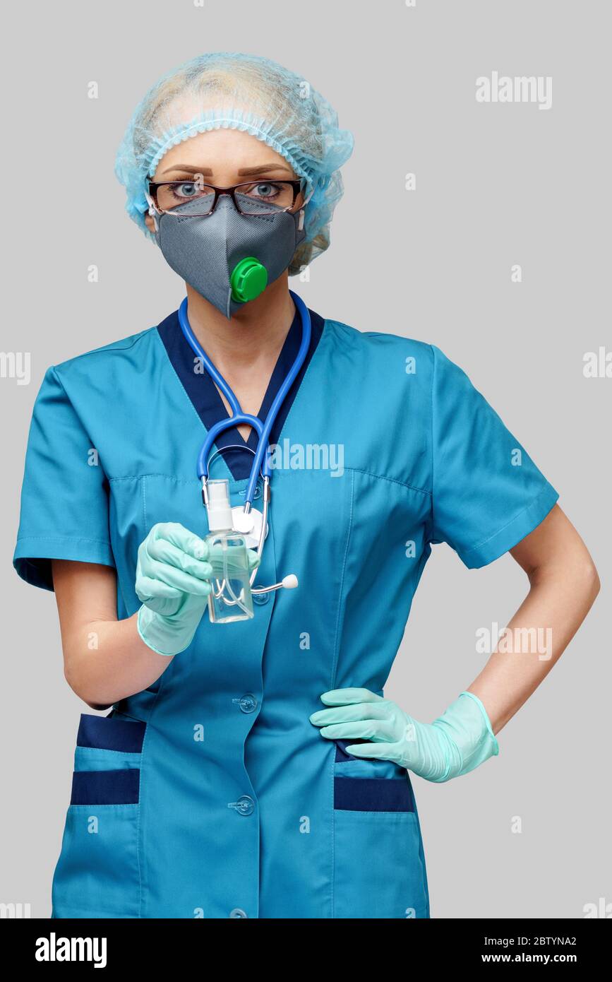 medico medico infermiere che indossa la maschera protettiva - contenente il flacone di spray o gel igienizzante Foto Stock