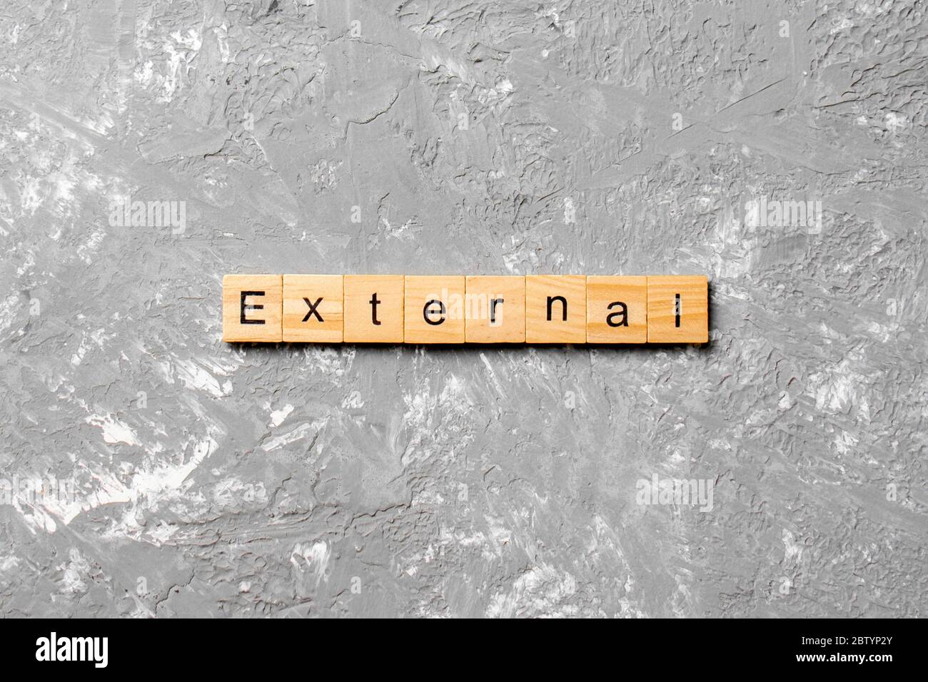 Parola ESTERNA scritta su blocco di legno. Testo ESTERNO su tabella di cemento per il vostro desing, concetto. Foto Stock