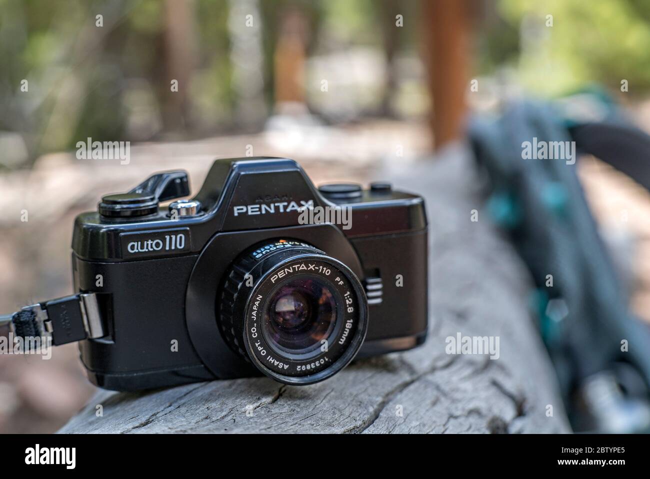 Pentax Auto 110 e 18mm lente di messa a fuoco che riposa su un registro durante una pausa durante un'escursione Foto Stock