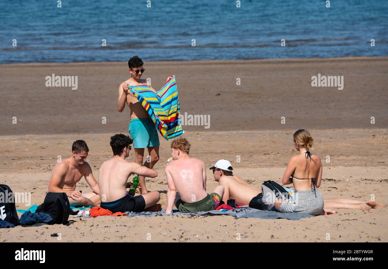 Portobello, Scozia, Regno Unito. 28 maggio 2020. Il caldo clima soleggiato con temperature che raggiungono i 24°C ha portato molte persone alla spiaggia e alla passeggiata a Portobello, Edimburgo. Il pubblico sembra sentire che il blocco è in fase di relax stanno approfittando del bel tempo per prendere il sole e godere dei molti caffè che ora offrono spuntini da asporto. Iain Masterton/Alamy Live News Foto Stock